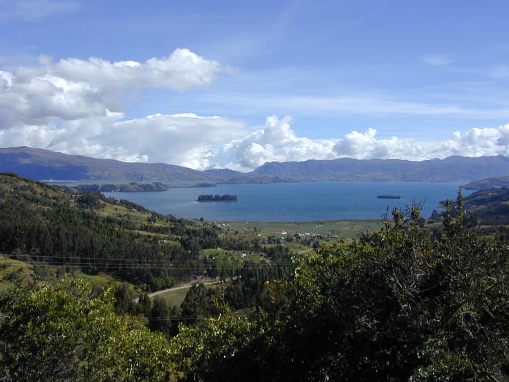 Forests in the foregroud give way to Lake Tota in the distance, surrounded by mountains on its far shores.
