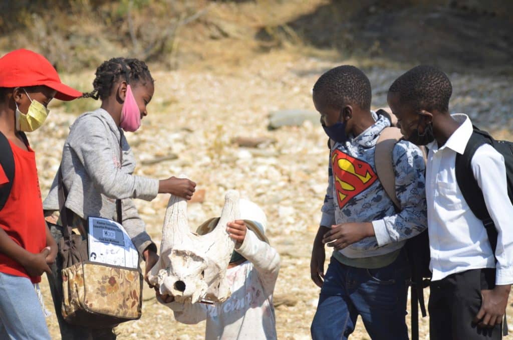 Students inspect a giraffe skull as a part of the KEEP programme (Image Credits: Giraffe Conservation Foundation).