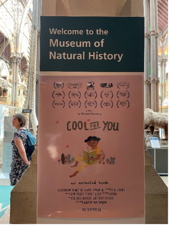 A sign welcoming visitors to the Museum of Natural History. Underneath, an ad for "Cool for You: an animated book," a film by Sherene Strausberg.