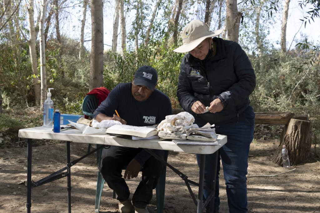 Alejandra Calvo and Mr. Catán, a local resident and now a bird expert, registering the biometric data of one of the captured birds before releasing them back into the wild.