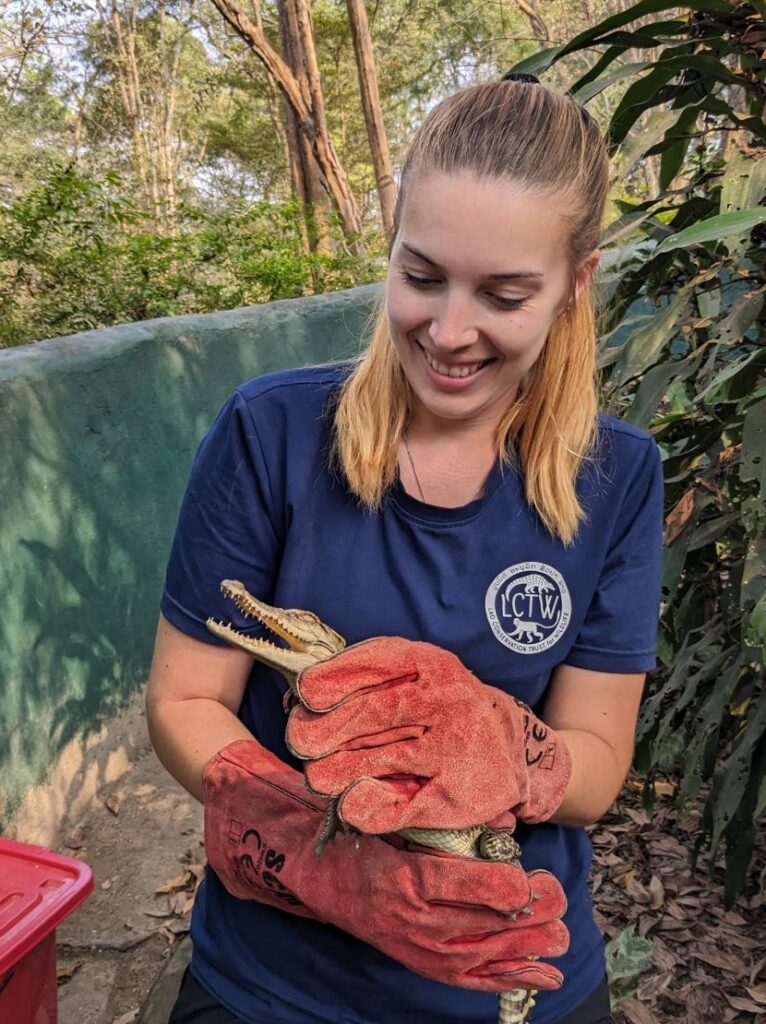 Amber with young crocodile in their rescue centre